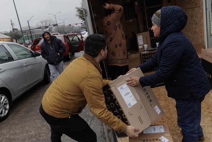Dora Portello, right, hands out boxes of free food to help people outside of their store, Brianna’s Home Decor Thrift Shop, during the winter weather that went through Dallas on Feb. 2, 2023.