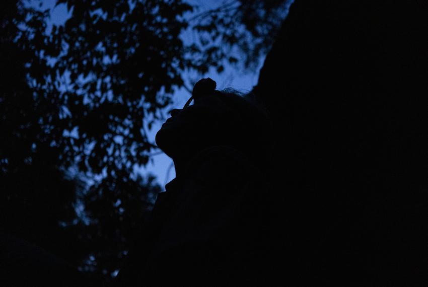 Debbie Hicks, Texas State Park Ranger, watches hundreds of bats emerge from Gorman Cave during a visit to survey the bat population at Colorado Bend State Park in Bend on July 13, 2023.