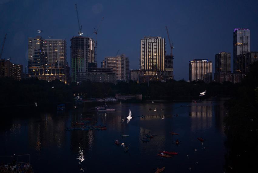 Tourists watch on kayaks, paddle boards and boats as Mexican free-tailed bats emerge from their roost at the Congress Avenue Bridge in Austin on July 28, 2023. According to Texas Parks and Wildlife, the Congress Avenue Bridge hosts the largest urban bat colony in the world, estimated at 1.5 million bats.