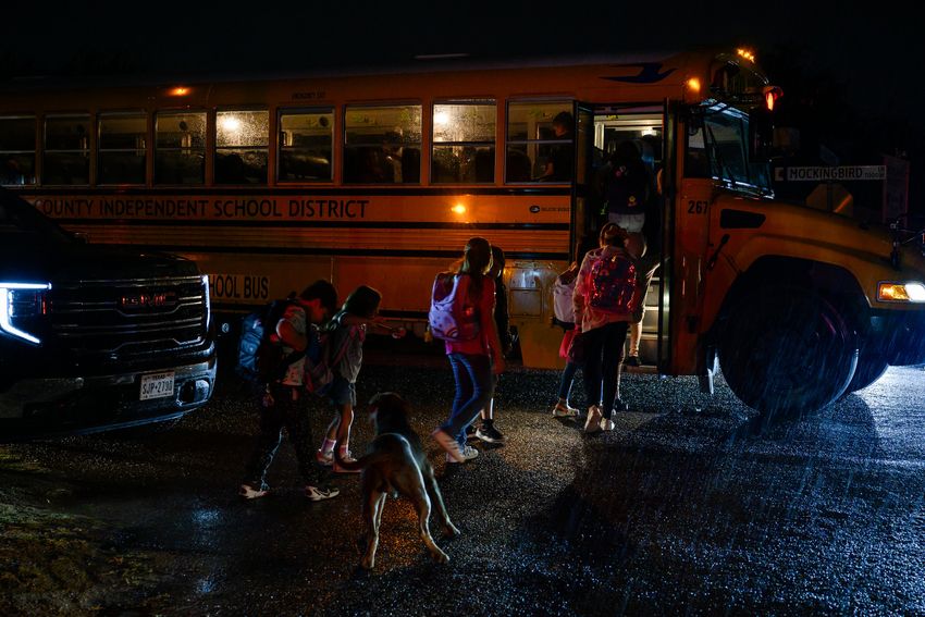 Children in West Odessa line up to board their school bus before dawn on Tuesday, Sept. 12, 2023.