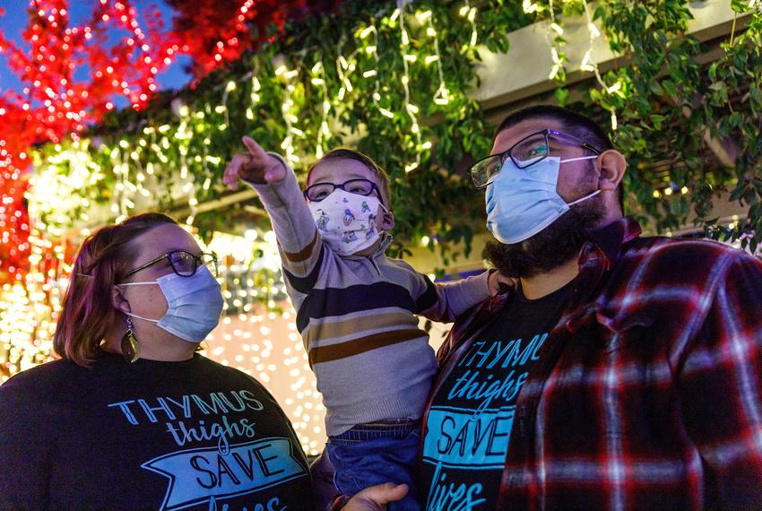 Gabe Nolasco points to a decoration during a holiday light exhibit outside of Cook's Children's Medical Center in Fort Worth, Texas on Dec. 2, 2023. Gabe Nolasco, 4, is currently recovering from a thymus transplant as treatment for his congenital athymia. As such, the Nolascos quarantine and wear masks in spaces with other people in order to avoid contamination.