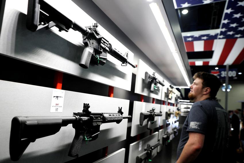 A man looks at assault-style rifles during the National Rifle Association annual convention in Houston on May 27, 2022.