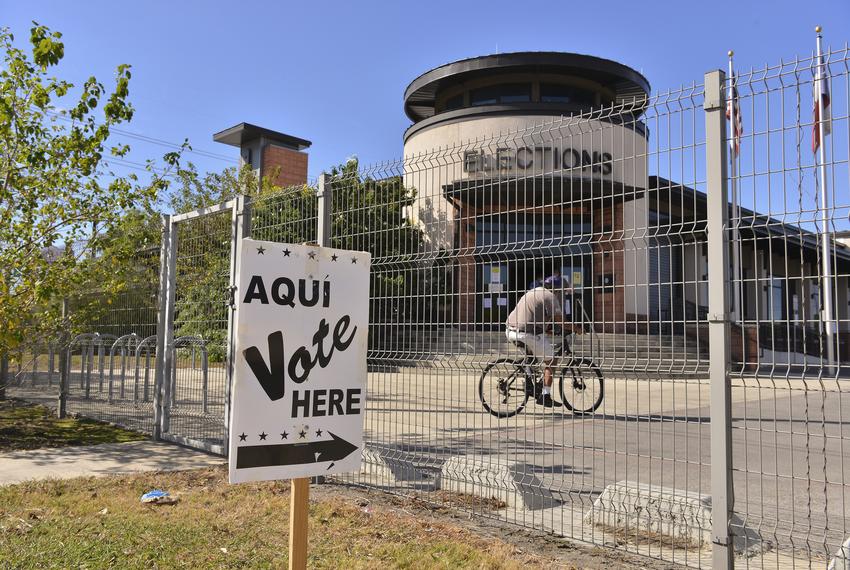 A man pedals his bike away from the Bexar County Election headquarters in San Antonio casting his ballot. Nov. 3, 2020. 