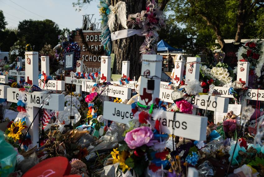 Hundreds of flowers, toys, and candles surround the crosses in memorial of the 21 victims of the school shooting at Robb Elementary in Uvalde, on June 9, 2022.