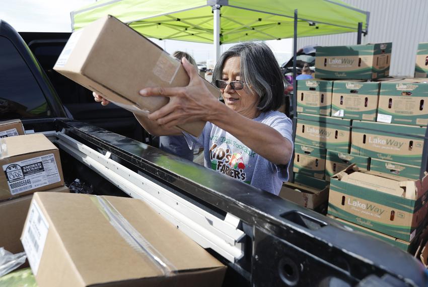 Yuchih Choy loads boxes of food into a pickup. West Texas Food Bank employees and volunteers load donated food into customer's cars during their weekly pick up outside of the food bank in Odessa, TX. Oct. 5, 2022.